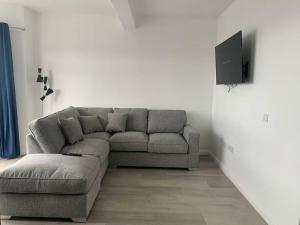 a living room with a couch and a flat screen tv at Modern appartment with sea views in Portrush