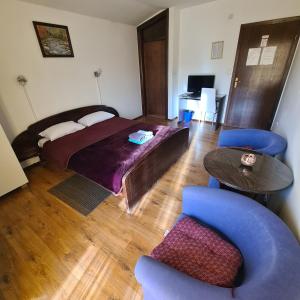 1 dormitorio con 1 cama, mesa y sillas en Guesthouse Kod mosta, en Karlovac