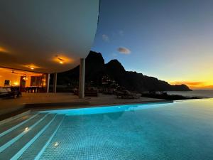 a swimming pool in a villa with a view of the ocean at Palmeira Da Cruz EcoLodge in Chã da Igreja