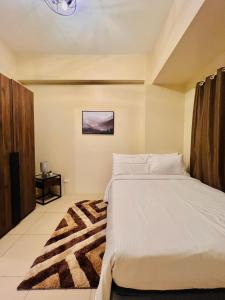 a bedroom with a white bed and a rug at * * Y Stylish 2BR Option for 6 in Iloilo City