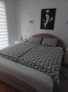 a bedroom with a bed with a black and white comforter at Apartment Harmony in Višegrad