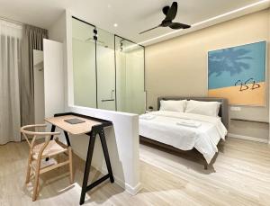a bedroom with a bed and a table with a chair at Designer Guesthouse Pulau Tikus & Gurney Drive, Georgetown, Penang in George Town