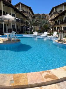 ein großer Pool mit Stühlen in einem Hotel in der Unterkunft Apto 2 quartos - Condomínio Frente Mar in Beberibe