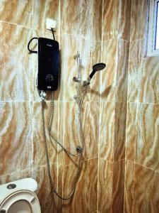 a bathroom with a toilet and wires on the wall at LANGKAWI FAMILY DELUXE HOUSE FOR 7Pax in Kuah