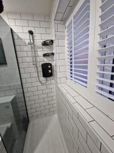 baño con bañera y ventana en Stylish 2 Bedroom Apartment Sleeps 4 Contractors and Corporates Welcome, en Birmingham