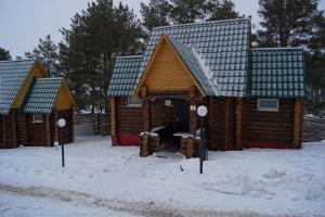 un grupo de cabañas de madera en la nieve en Baza Otdykha Ivolga, en Ulyanovsk