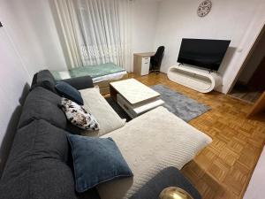 a living room with a couch and a flat screen tv at Stilvolle 2-Zimmer-Anliegerwohnung in Tuttlingen in Tuttlingen