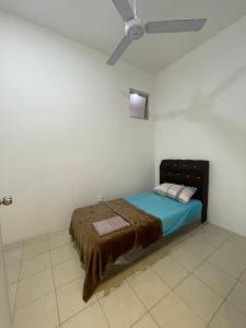 - une chambre avec un lit et un ventilateur de plafond dans l'établissement HM HOMESTAY TAWAU, à Kampong Parit