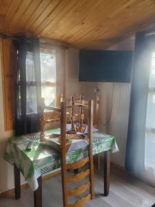 - une table et des chaises dans une chambre dotée d'un plafond en bois dans l'établissement L'escale en Dordogne, à Saint-Antoine-de-Breuilh