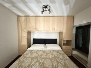 uma cama num pequeno quarto com armários e uma cama sidx sidx em DOMUS ESSENTIA em Pofi
