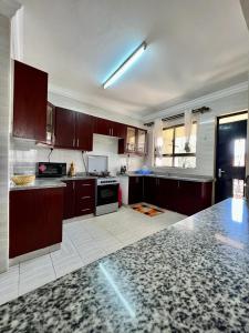 a large kitchen with wooden cabinets and a stove at Paradise palace in Nairobi