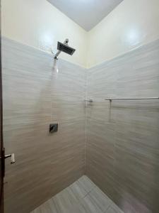 a bathroom with a shower with a glass wall at Paradise palace in Nairobi