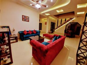 a living room with two red couches and a table at PANCHHI'S NEST Villa in Amritsar