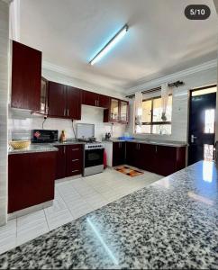 a kitchen with brown cabinets and a white tile floor at Paradise palace in Nairobi