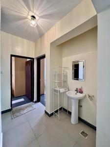 ein Bad mit einem Waschbecken und einem Spiegel in der Unterkunft Paradise palace in Nairobi