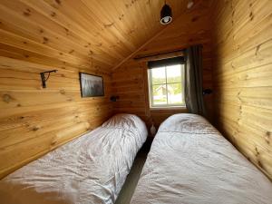 two beds in a log cabin with a window at Vrådal Panorama in Sinnes
