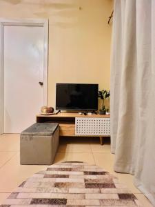 un soggiorno con TV su un tavolo di * * Y Stylish 2BR Option for 6 a Città di Iloilo Altre 12 foto