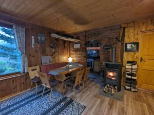 a dining room with a table and a wood stove at Beutners Berghütte in Stützerbach