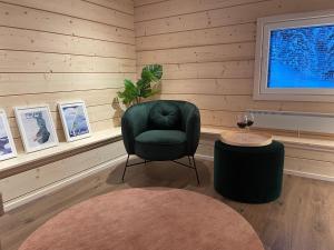 a living room with a green chair and a table at Miilu Resort in Ylläsjärvi