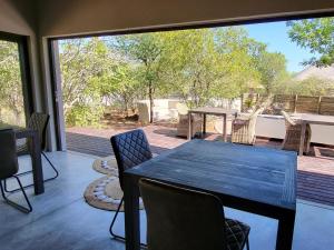 a dining room with a table and chairs on a deck at Taaibos Bush Lodge in Hoedspruit