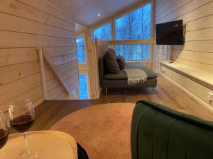 una stanza con una sedia e un tavolo con bicchieri da vino di Miilu Resort a Ylläsjärvi