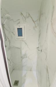 La salle de bains est pourvue d'une douche en marbre blanc. dans l'établissement Sweet home, à Barcelone