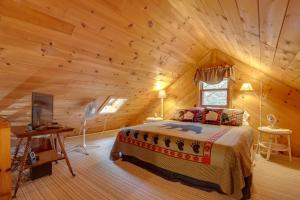 1 dormitorio con 1 cama en una cabaña de madera en Lakefront Rhinelander Cabin with Dock and Fire Pit!, en Rhinelander