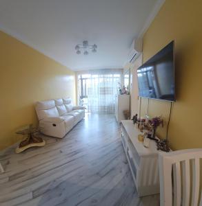 Sweet home في برشلونة: غرفة معيشة مع أريكة بيضاء وتلفزيون بشاشة مسطحة