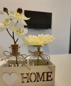 a vase with flowers in it with a home sign at Charbonnel 2 Bruxelles-Charleroi-airport in Charleroi
