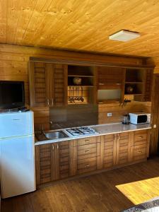 a kitchen with wooden cabinets and a white refrigerator at Guest House Kaspiy in Bukovel