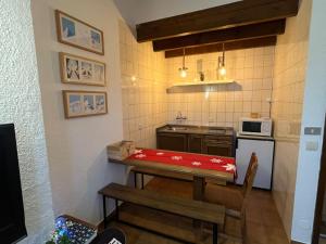 eine kleine Küche mit einem Tisch und einem Herd in der Unterkunft Apartamento esqui montaña Cofiñal in Cofiñal