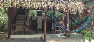 a hut with a thatch roof and a hammock at Casa Embira - 300 metros da Praia do Lago Verde in Alter do Chao