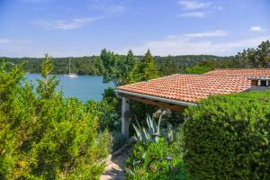 een huis met uitzicht op een meer en een boot bij Holiday Home Paradise Beach in Šibenik