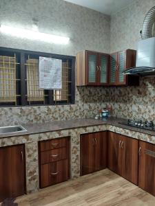 a kitchen with wooden cabinets and a counter top at Taj Mahal Hotel in Cochin