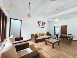 ein Wohnzimmer mit einem Sofa und einem Tisch in der Unterkunft Galle Face Terrace Hostel by Tourlux in Colombo