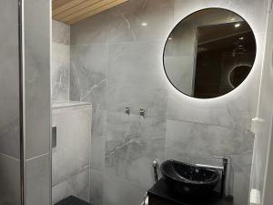 a bathroom with a sink and a mirror at Villa Auroras Kettu in Syöte