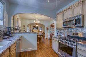 uma grande cozinha com electrodomésticos brancos e uma sala de jantar em Charming Villa Espagna - Heated/Salt-Pool Oasis! em Lake Worth