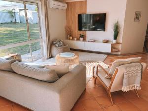 een woonkamer met een bank en een tv bij BEACH 400m, Big Yard, Playroom, Perfect for Families, Couples, Digital Nomads in Mandurah