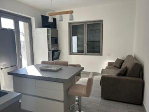 a kitchen and living room with a table and a couch at le camelie del Lario in Grandate