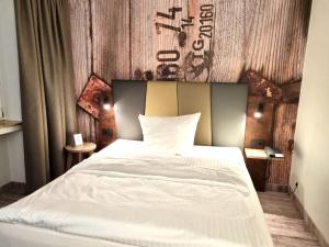 a bedroom with a white bed with a sign on the wall at Hotel Bavaria Oldenburg in Oldenburg