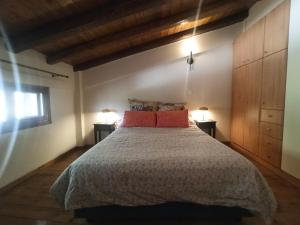 a bedroom with a bed with two lamps on two tables at Helmos Mountain Retreat in Zarouhla