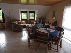 ein Wohnzimmer mit einem Tisch und einem Sofa in der Unterkunft Ferienwohnung Meisenthal nähe Nürburgring in Kelberg