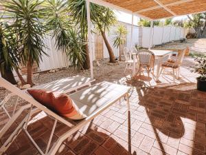 un patio con sillas, mesa y sillas en BEACH 400m, Big Yard, Playroom, Perfect for Families, Couples, Digital Nomads en Mandurah