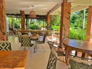 an empty restaurant with tables and chairs and tables and chairs at Hotel La Casablanca Tayrona in Calabazo