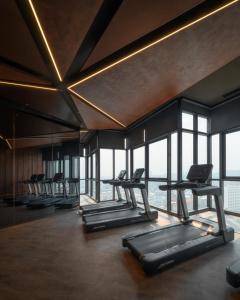 a gym with a row of treadmills and windows at The EDGE Central Pattaya in Pattaya Central