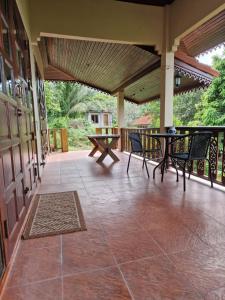 een patio met tafels en stoelen op een veranda bij Bungalow vue mer in Nathon Bay