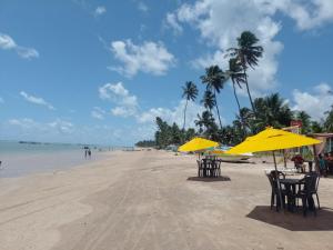 a beach with chairs and umbrellas on the sand at Casa morada da praia 5 in Peroba