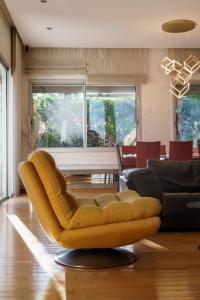 a living room with a yellow couch and a table at Luxury villa Bouskoura Pearl in Casablanca
