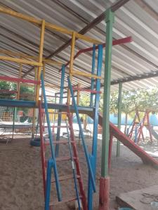 un parque infantil con equipamiento colorido en un edificio en Casa morada da praia 5, en Peroba