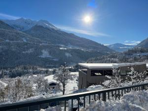 vistas a una montaña cubierta de nieve y a un edificio en Traumapartment Murmeltier Tirol, en Grins